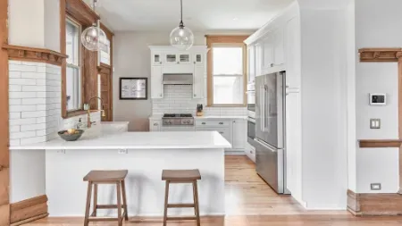 Modern kitchen with white cabinets, large island and black stainless steel fixtures