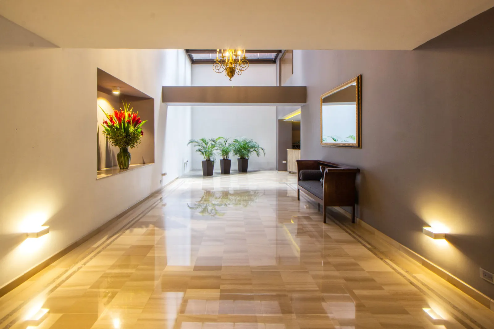 Polished marble tile flooring in a grand hallway with decorative inlay borders and warm accent lighting